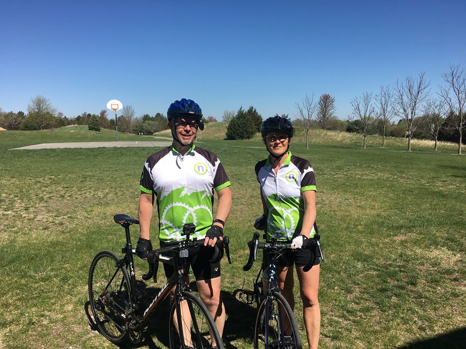 Two Nelnet associates posing in a field with their bikes