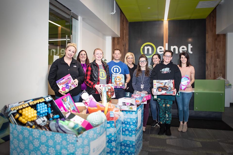 Nelnet associates posing in front of toys from charity drive