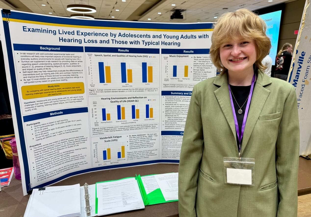 Lily Ardinger standing next to her poster presentation