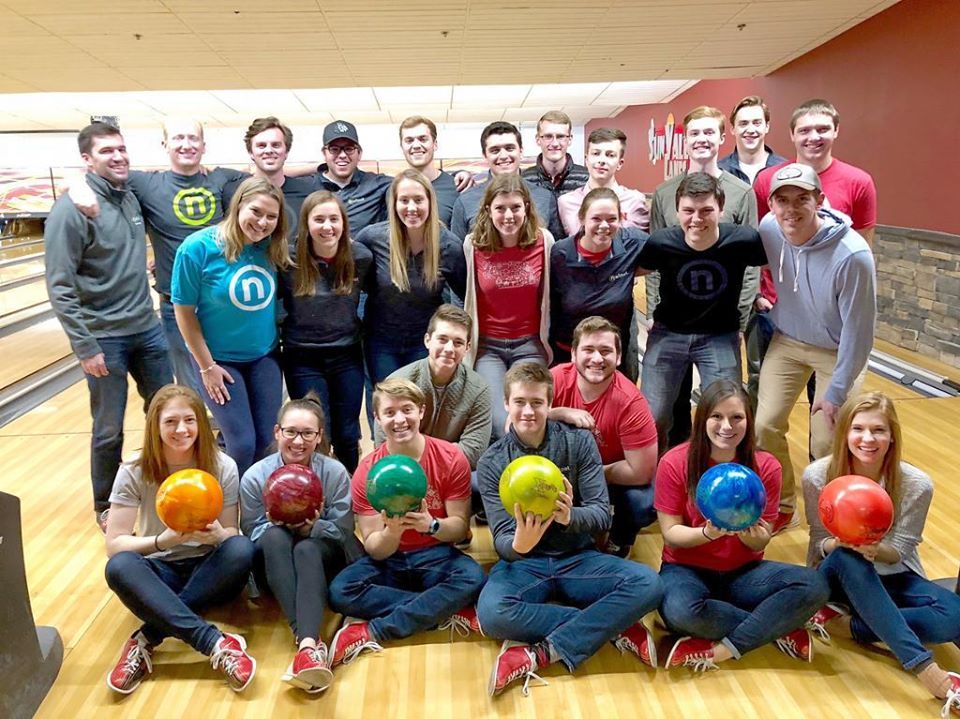 Nelnet associates at bowling alley posing with bowling balls