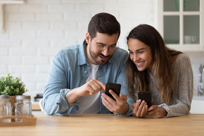 A man showing a woman something on his smartphone